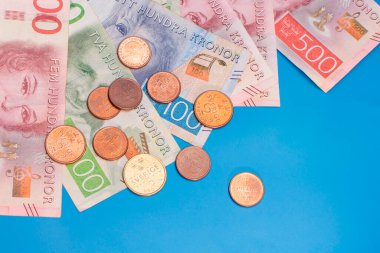 İsveç krona banknotları, farklı mezhepler ve bozuk paralar mavi arka planda. Yüksek kalite fotoğraf