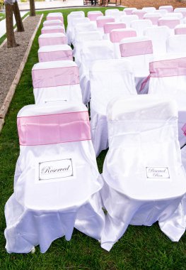 Düğünde süslü sandalyeler ve ayırtılmış tabelalar.