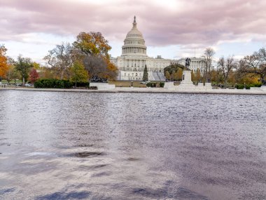 Washington DC 'deki gururlu başkent binasında gölet ve bulutlar gökyüzünde