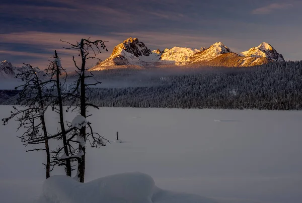 Sunrise on Redfish lake in winter with snow and fog
