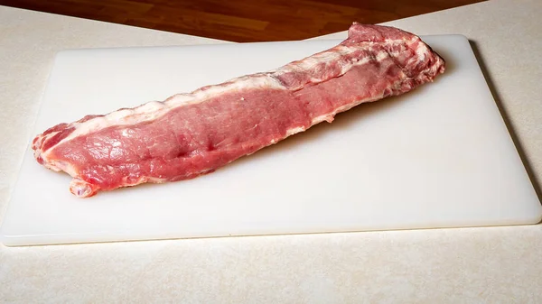 未煮熟或调味的猪肉排骨放在准备好的切菜板上 — 图库照片