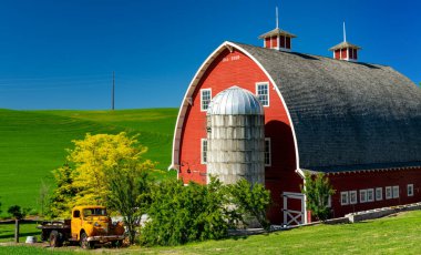 Farm in Eastern Washington with a bright red barn and yellow pickup