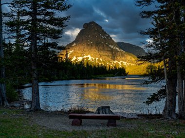 Perfect view of sunrise from a bench on the shore of a Glacier Montana Lake