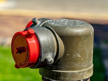 Red cap over large water hose outlet outdoors