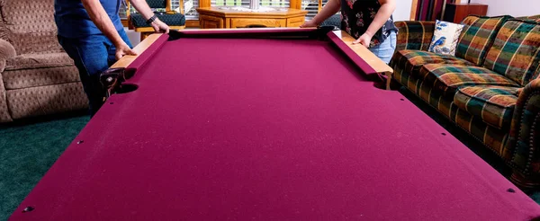 Red felt pool table is in the process of disassembly