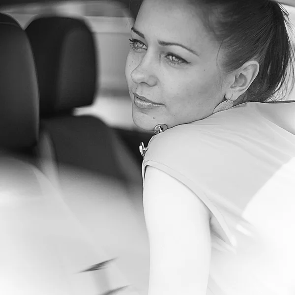 Beautiful girl sitting in a car.Black and white colors