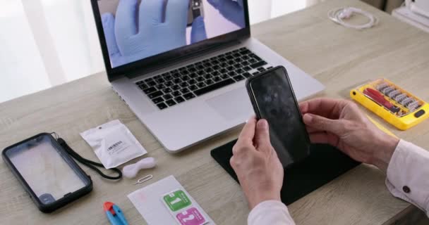의사들의 손 이 휴대 전화 수리 동영상 과 관련하여 전화 화면을 닦고 있다 — 비디오