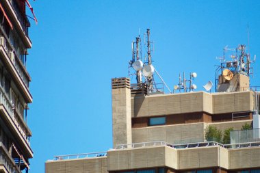 group of telecommunications antennas on building roof