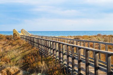 Mavi plajlarda yıkanmak için sahile ulaşmak için ahşap yol.