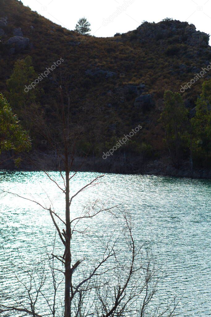 Beautiful landscape of the Embalse de la Cierva in Murcia with the reflection of the sun in the water with gentle waves