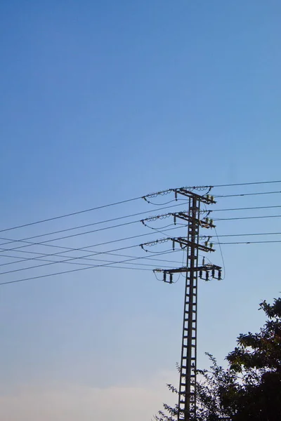 事業や家庭に電力を供給するケーブル付きの金属製の塔 — ストック写真
