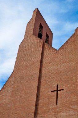 Çan kulesi ve çanları olan modern tuğla kilise.
