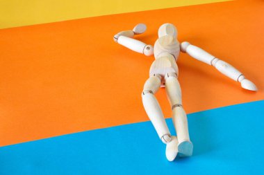 Concept of a tourist resting on the shore of the beach enjoying his vacation with an articulated wooden doll