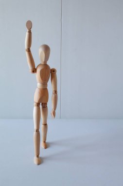 Greeting or leadership concept represented in a wooden doll