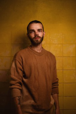 Kontrastlı ışıkta zalim adam sarı fayanslara karşı. Yüksek kalite fotoğraf