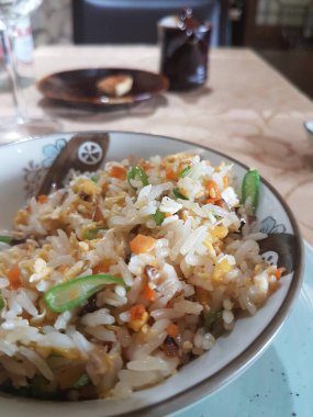 Japon pilavı ve altın masa örtüsü olan bir çaydanlık.