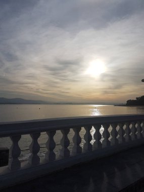 Bulutlu bir günde Magdalena sahilinde beyaz korkuluklar. Güneş Santander Körfezi 'ndeki denize yansıyor..