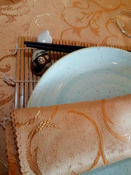 金色のテーブルクロスに黒箸 寿司マット — ストック写真