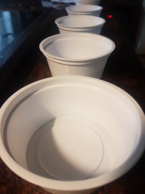 Doldurulması gereken bir sürü beyaz plastik kap var.