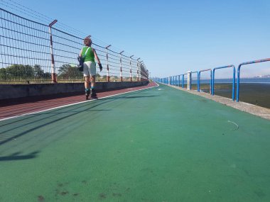 Yeşil beyaz paten giyen yaşlı kadın.