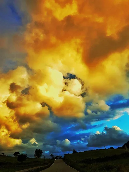 องฟ นสดใส องฟ เมฆมาก ถนนชนบทในท งหญ นไม — ภาพถ่ายสต็อก