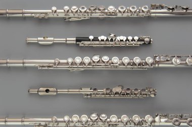 Büyük ve küçük flütler gri bir yüzeye yayılır.