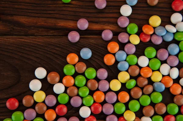 Hintergrund Form Kleiner Runder Farbiger Bonbons Auf Einem Hölzernen Hintergrund — Stockfoto