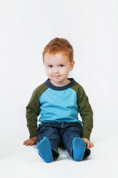 Redhead little boy sitting on the floor smiling — Stock Photo, Image