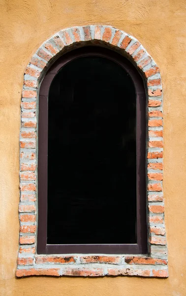 Винтажное окно на желтой цементной стене — стоковое фото