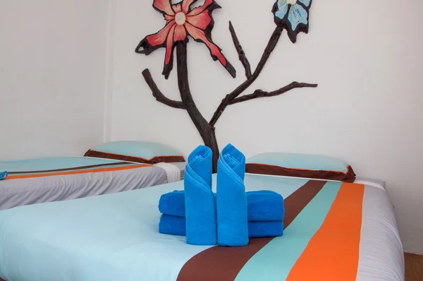 Blauwe handdoek roll wordt op het bed geplaatst. — Stockfoto