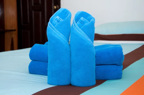 Blue towel roll is placed on the bed. — Stock Photo, Image