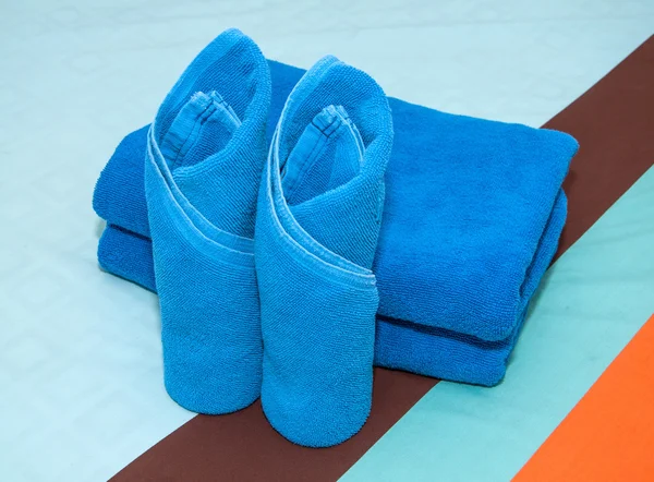 Rollo de toalla azul en la cama . — Foto de Stock