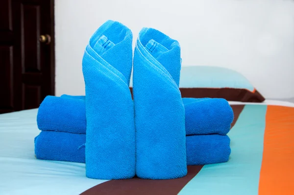 Blue towel roll is placed on the bed. — Stock Photo, Image