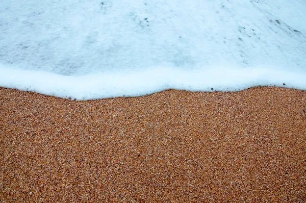 Våg av havet på sandstranden — Stockfoto