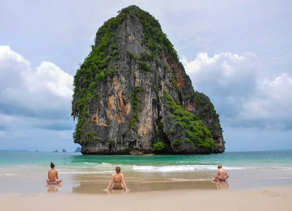 Frauen sitzen am Strand und schauen auf Meer und Insel. — Stockfoto