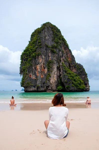 Ženy sedí na pláž, moře a ostrov. — Stock fotografie
