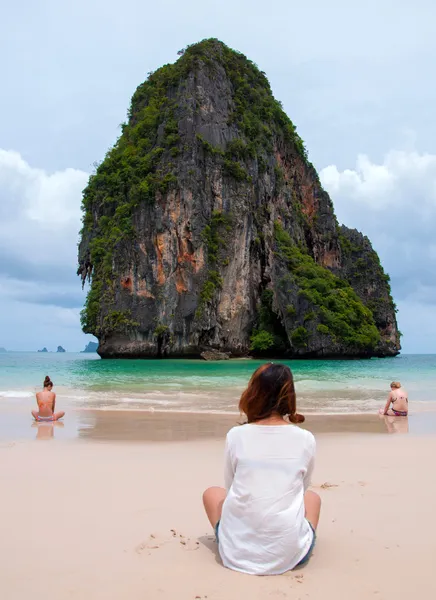 女性は海と島を探しているビーチの上に座る. — ストック写真