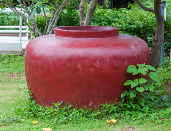 O velho frasco vermelho de cimento grande no jardim Fotografia De Stock