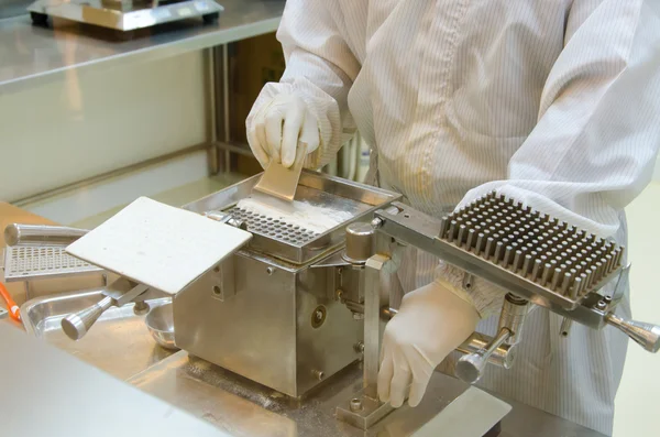 Pharmacist preparing medication with packaging capsule — Stock Photo, Image