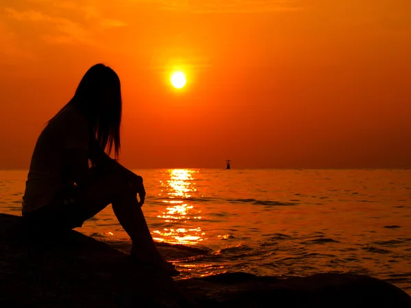 Eine Frau allein, die den Sonnenuntergang beobachtet — Stockfoto