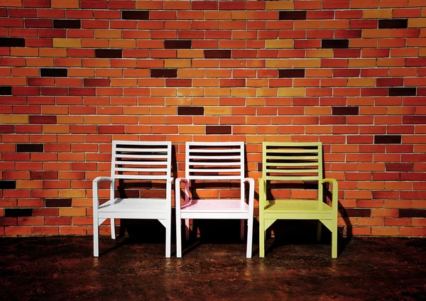Tři židle s krásných červených cihel na zeď pozadí — Stock fotografie