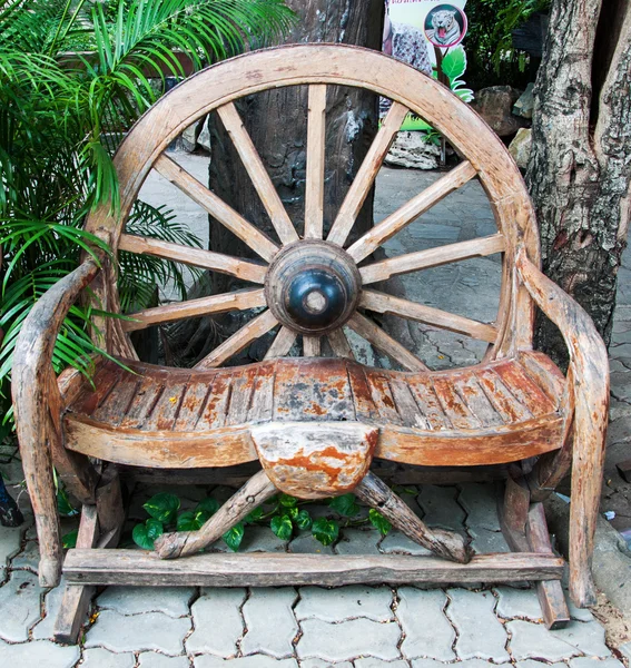 Antique bench made from carriage wheel in garden — Stock Photo, Image