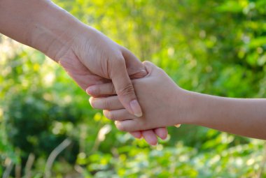 Anne ve kızı holding, arka planda yeşil park