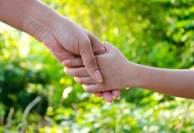 Anne ve kızı holding, arka planda yeşil park