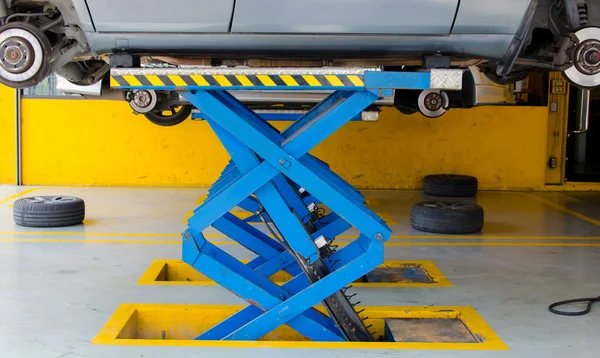 Car under repair on hoist at service station — Stock Photo, Image