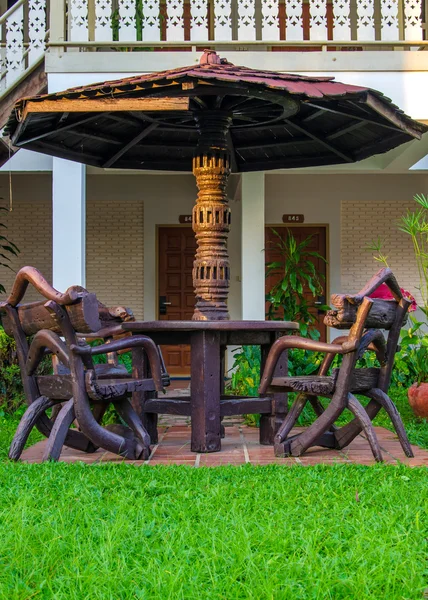 Tuinmeubilair. stoelen en tafel onder houten paraplu in gard — Stockfoto