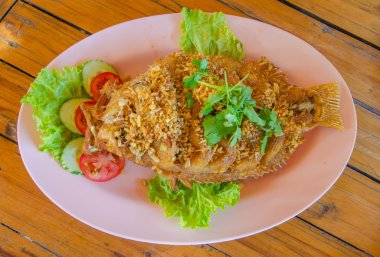 ahşap masa üzerinde kızarmış sarımsaklı kırmızı tilapia balık kızartma
