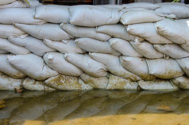 Savunma ve onun su yansıma kahverengi beyaz kum torbaları için sel