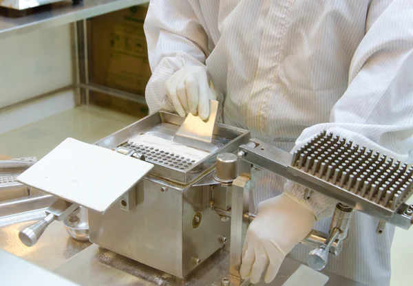 Pharmacist preparing medication with packaging capsule — Stock Photo, Image