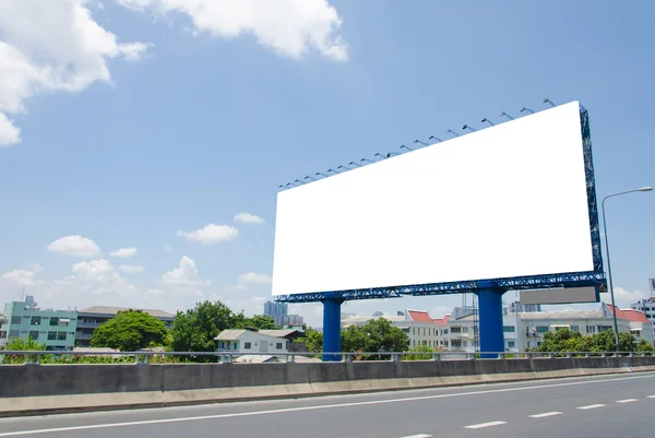 Grand panneau d'affichage blanc sur la route avec vue sur la ville arrière-plan — Photo